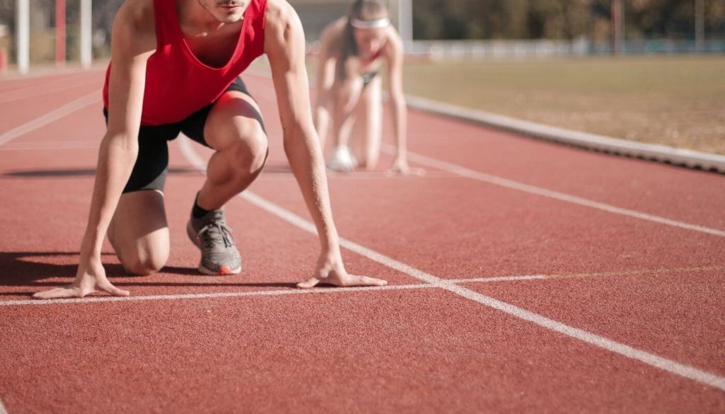 Start Wyzwania Frajdy - atleci na stadionowej bieżni tuż przed startem